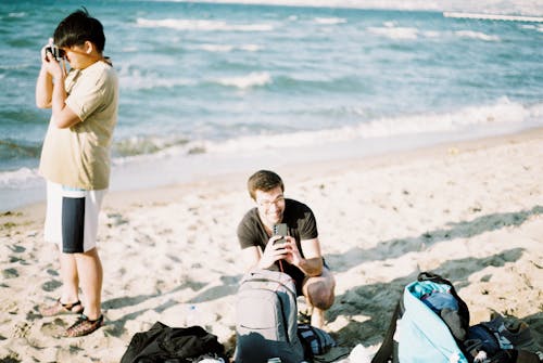 Man and Boy Photographing at Beach