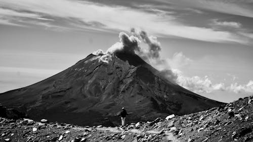 A Hiker Looking at a Smoking Volcano