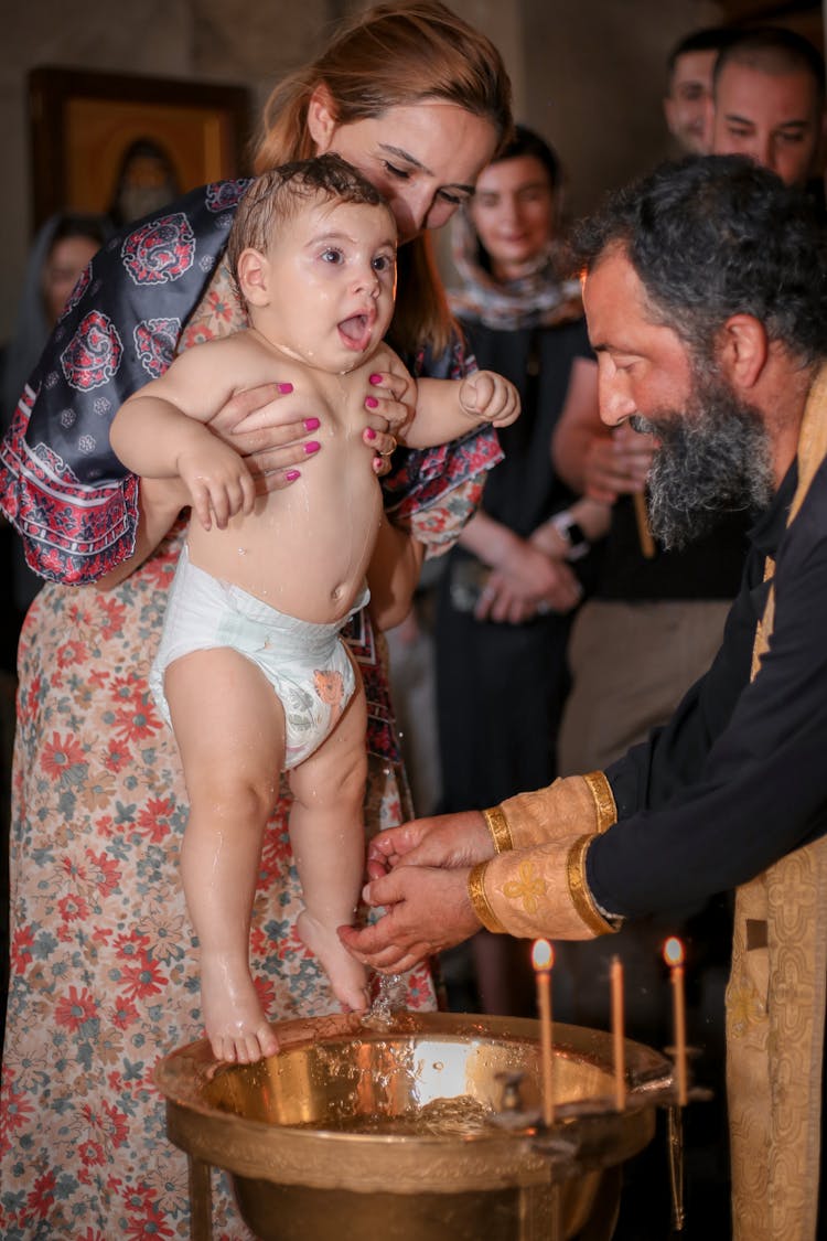 Woman Holding A Baby During Baptism