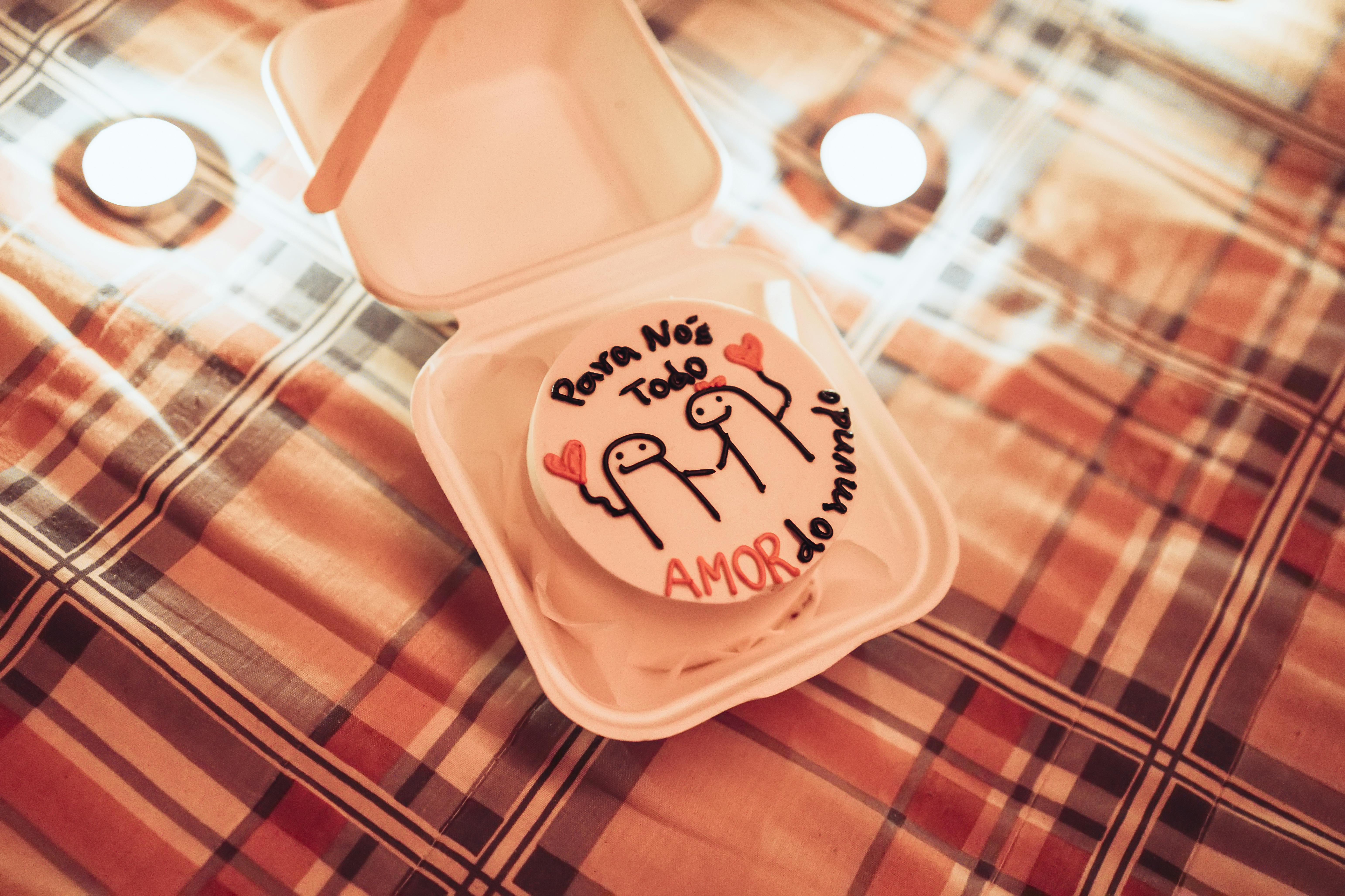A cozy romantic scene with a gift box displaying a love-themed artwork on a plaid background.
