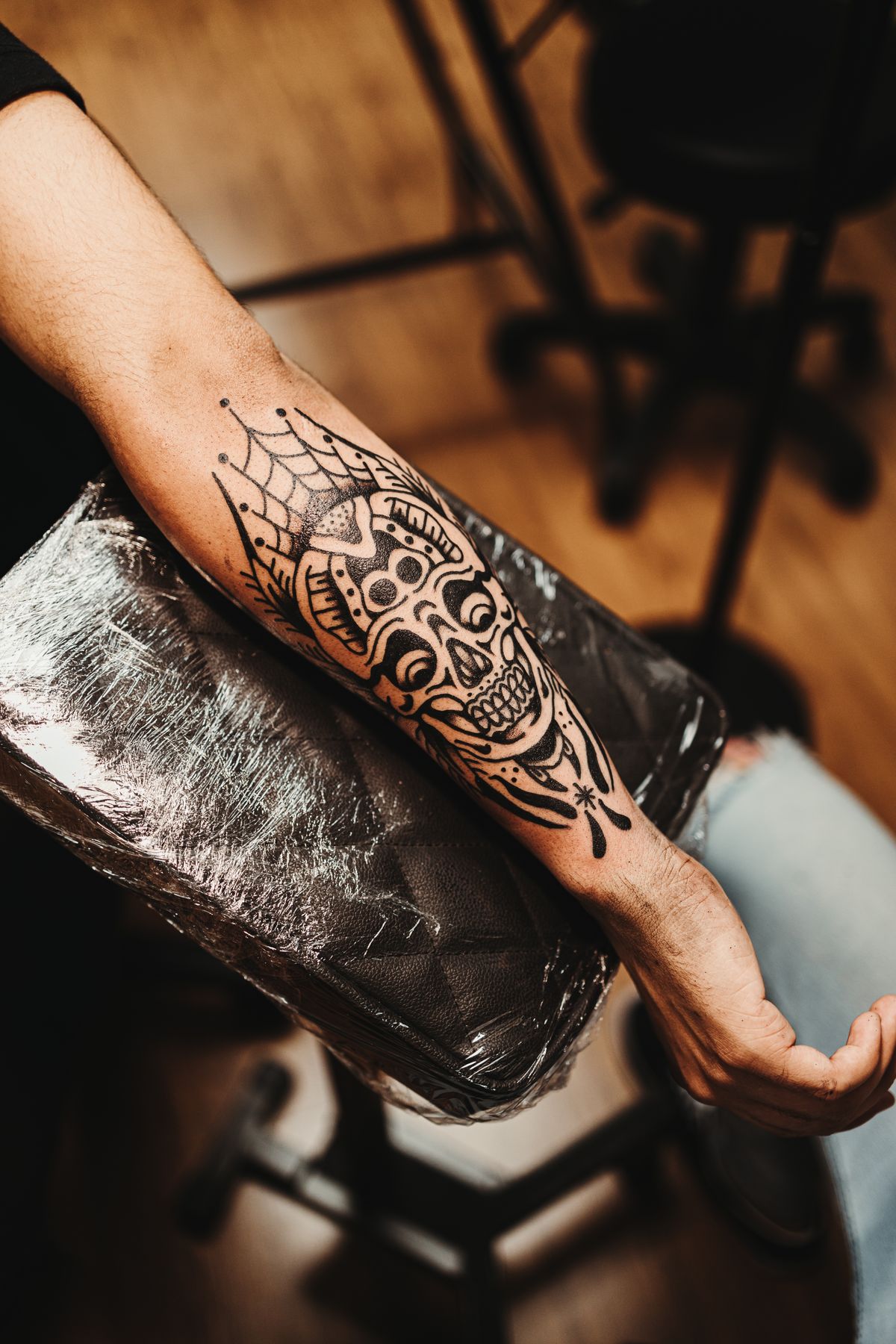 Blackwork skull and crown tattoo on a forearm