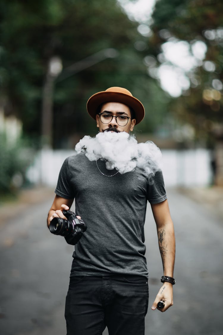 A Man Blowing Smoke While Walking