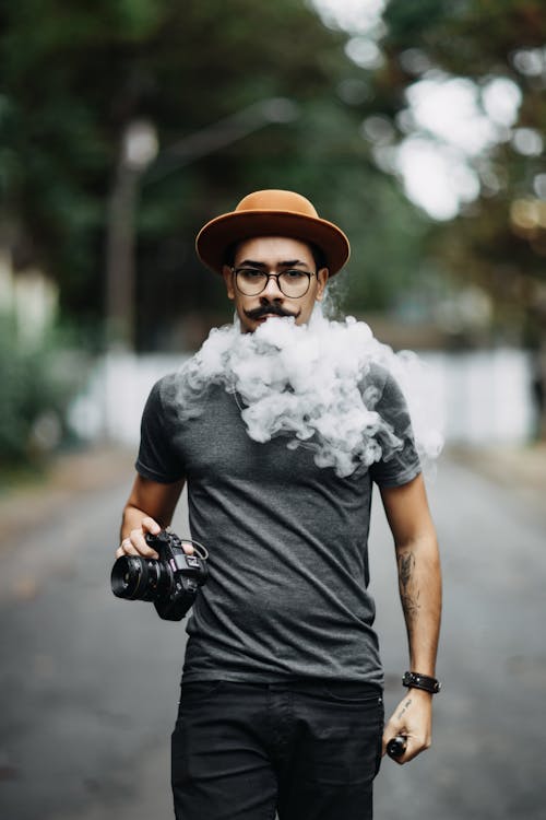 Man in Gray Shirt Blowing Out Vapor