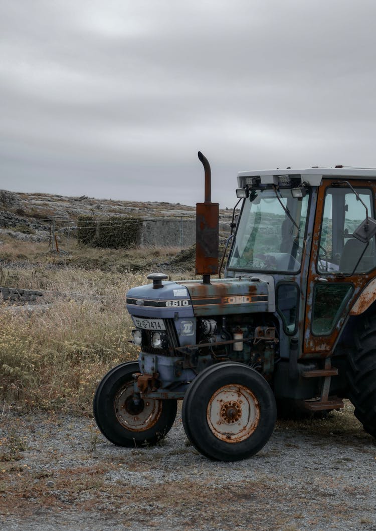 Rusty Tractor Parked On A Grass Field