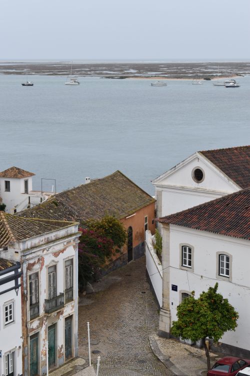 Free Aerial view of a charming coastal village with ocean horizon and boats. Stock Photo