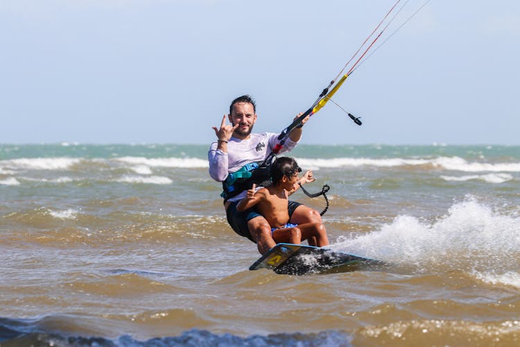 Man And Boy Kitesurfing Together