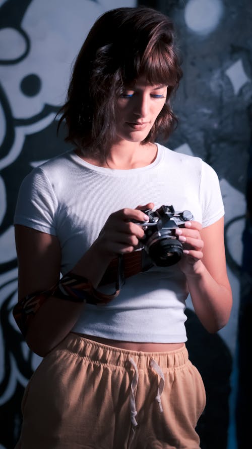 Woman in White Shirt Holding a Camera