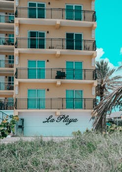 Stylish building exterior with balconies and palm trees at La Playa.