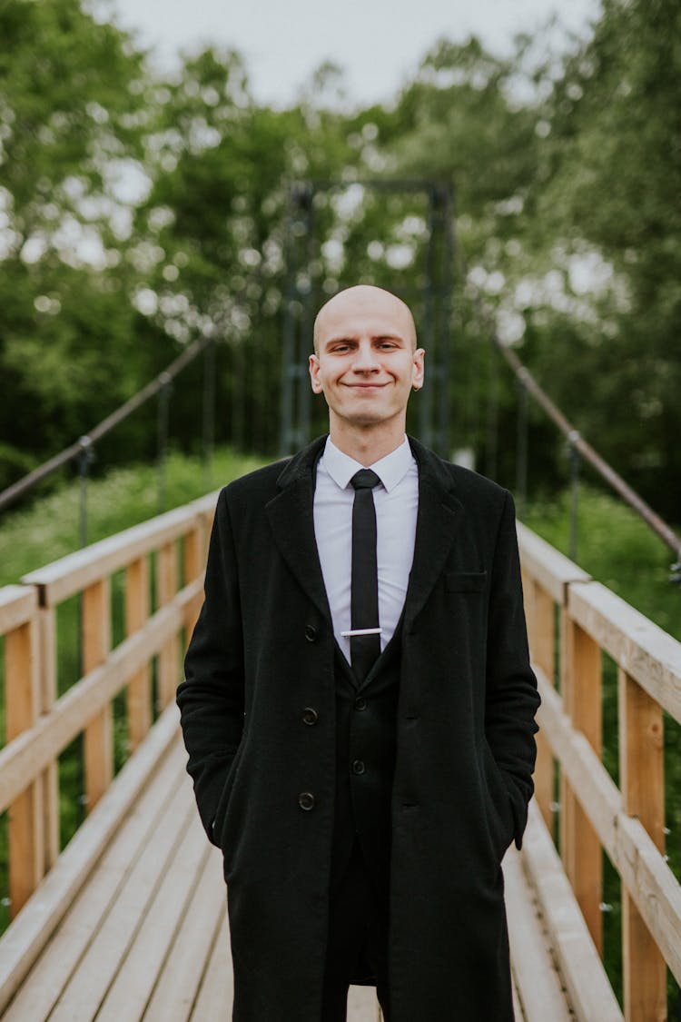 Bald Man In Coat On Bridge