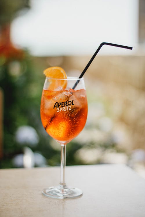 Photographie De Mise Au Point Peu Profonde De Verre à Vin Avec Tranche De Fruit Sur Le Dessus Du Bois Brun