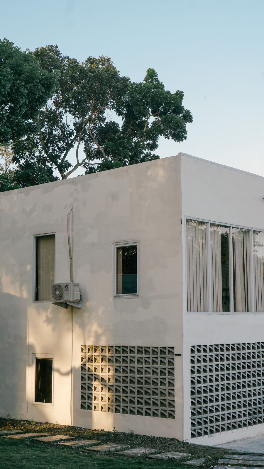 Casa Bloco: volume de concreto aparente entre árvores, em Itu
