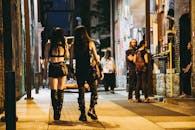 夜晚，穿着哥特式服装的人们走在热闹的城市街道上