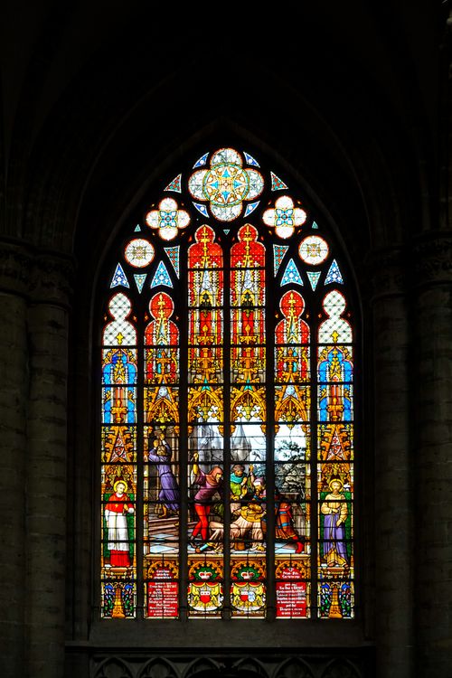 Free Intricate stained glass window depicting religious scenes in a gothic cathedral. Stock Photo