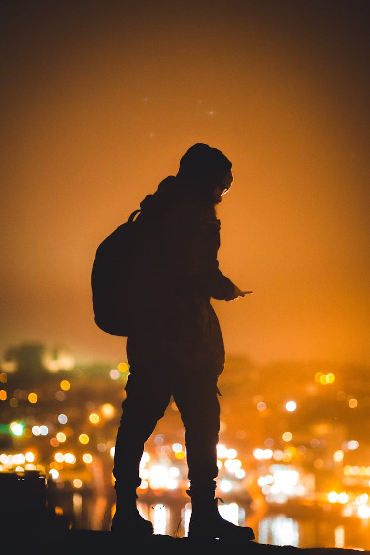 Silhouette Of A Standing Man Back Lit By City Lights