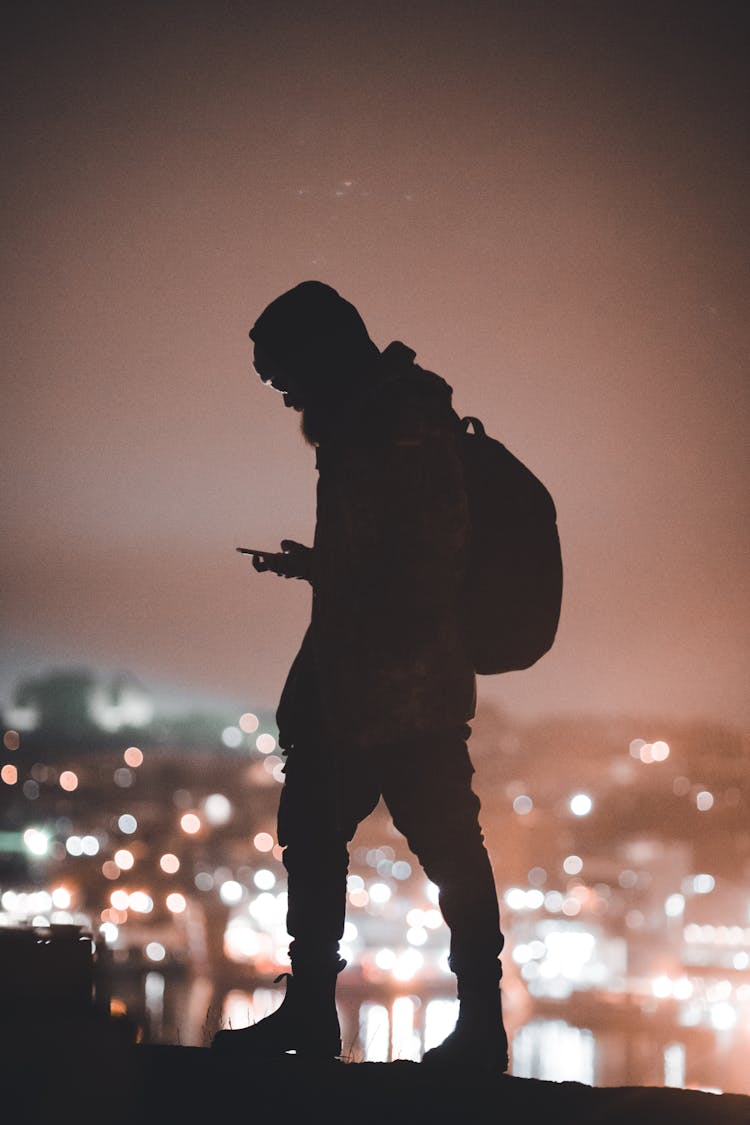 Silhouette Of A Man Using His Phone