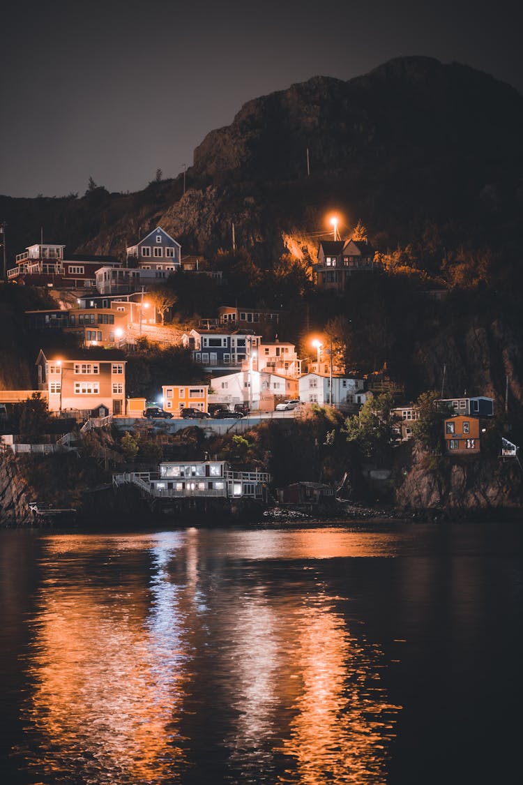 Houses On A Hill Over A Lake At Night