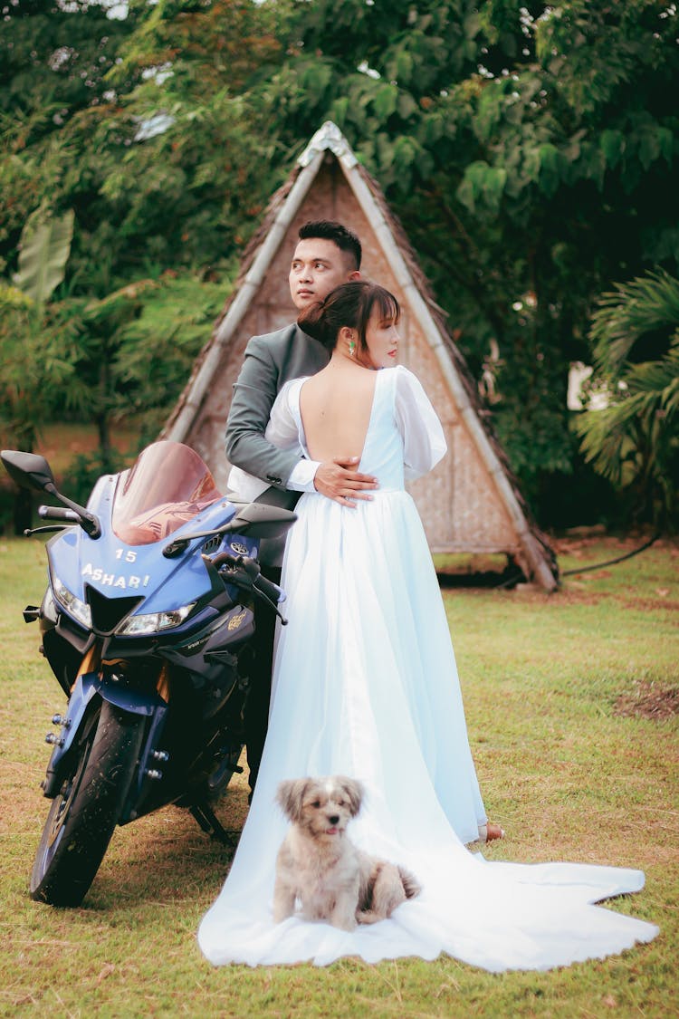 Bride And Groom Posing With Dog