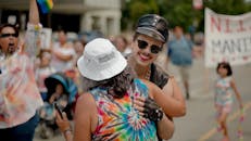 街头游行色彩缤纷，人们在户外庆祝、拥抱