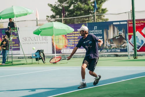 Man in Blue Shirt Playing Tennis