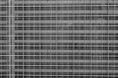 Free Monochrome photo of a modern building facade with grid pattern architecture. Stock Photo
