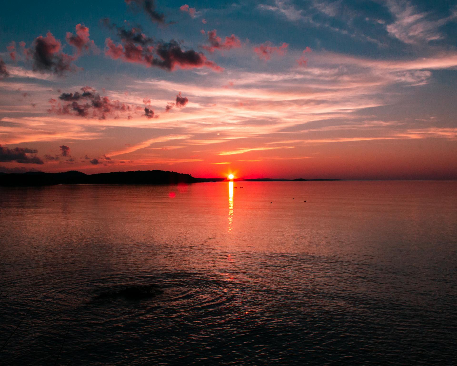Breathtaking sunset over Lake Superior with vibrant sky and sea reflection in Marquette, MI.
