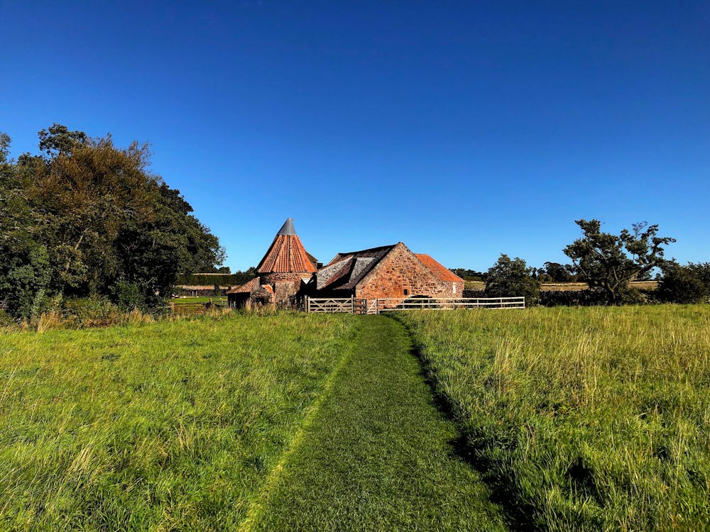 Farm House in the Grass Field