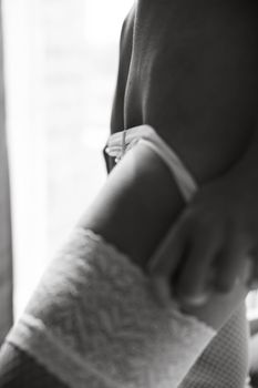 Artistic black and white close-up of a woman in lingerie showcasing elegance.