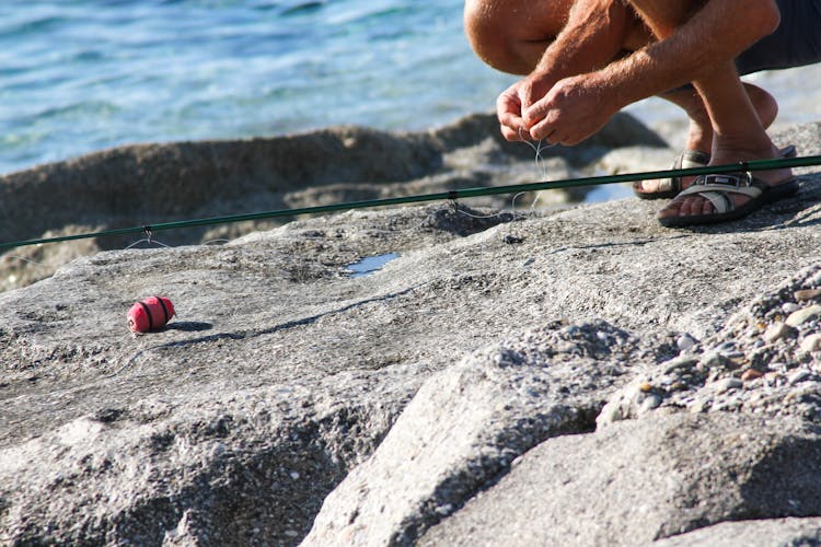 A Person Fixing A Fishing Rod