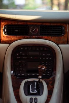 Close-up of a Jaguar car's interior featuring wood trim and gear shift.