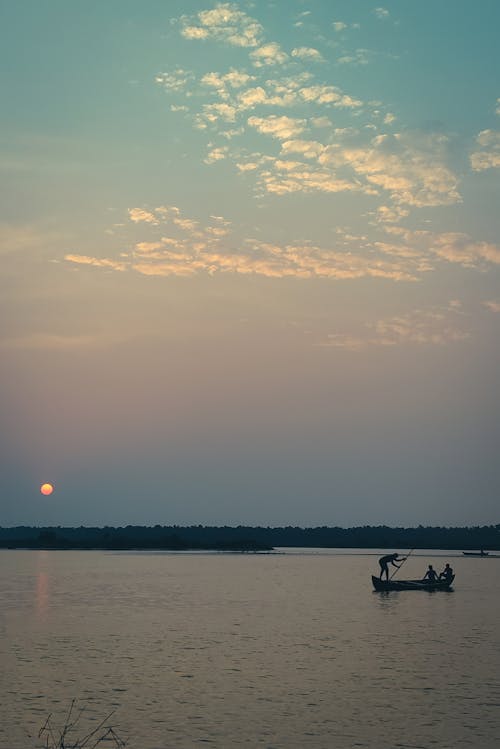 Silhouette of People Riding on Boat on Sea during Sunset