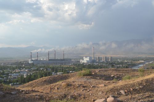 Free An industrial power station emitting smoke in a rural landscape under a cloudy sky. Stock Photo