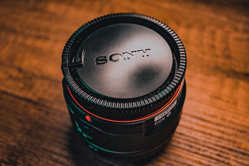 Close-Up Shot of a Camera Lens on Wooden Surface