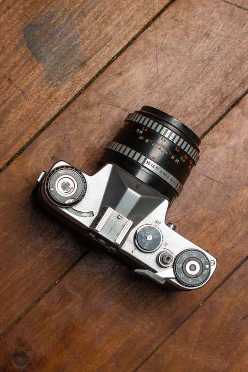 Free Top view of a vintage film camera placed on a wooden surface, showcasing its classic design. Stock Photo