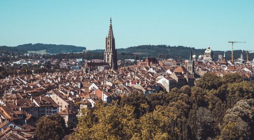 Free Aerial view of Bern, Switzerland featuring the iconic cathedral tower amidst historic rooftops. Stock Photo