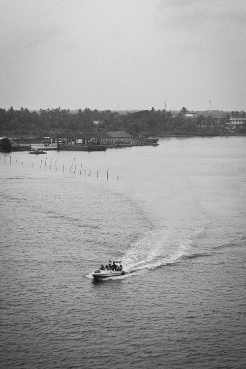 Free A speed boat cruises on Ashtamudi Lake in Kollam, India, captured from above. Stock Photo