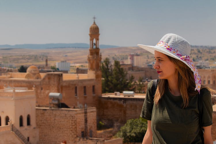 A Woman In Green Shirt Wearing A Hat