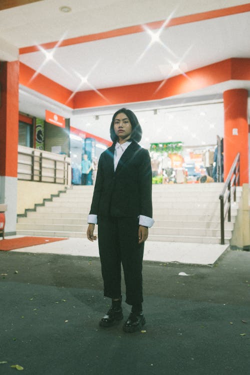 Young Woman in Suit Standing near Stairs