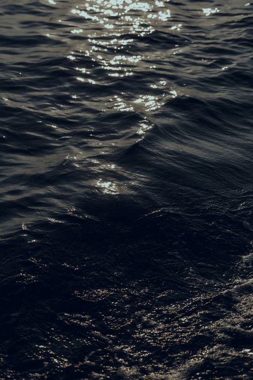 Free A serene monochrome view of ocean waves glistening under twilight sky. Stock Photo