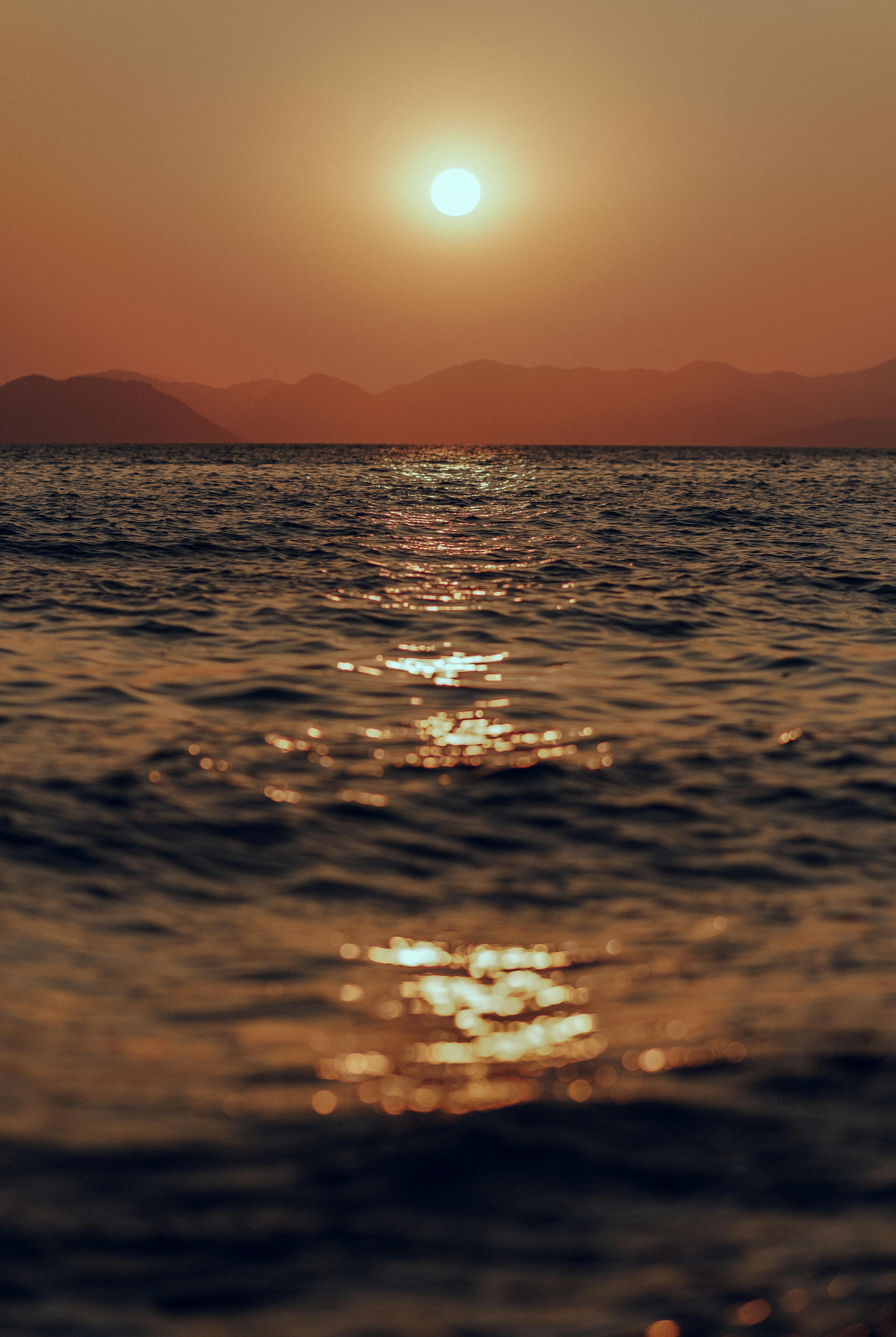 Serene ocean view at sunset with golden reflections on the water's surface.