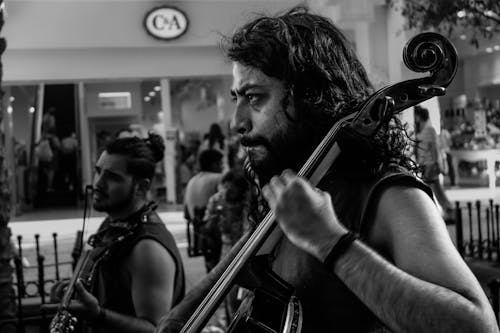 Black and White Shot of a Man Playing a Cello