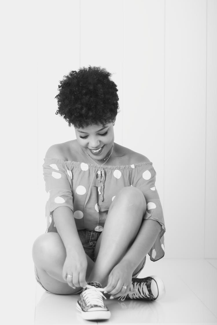 Smiling Woman On Studio Background Tying Shoes Laces