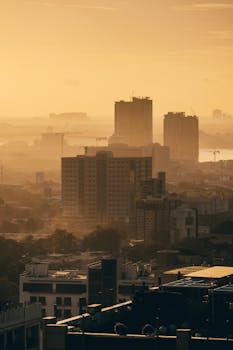Aerial view of Cebu City skyline during golden hour with high-rise buildings against a warm sunset.