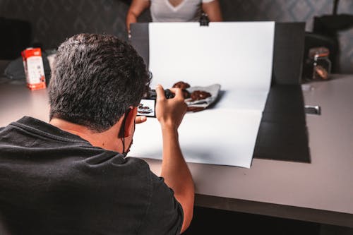 Back View of Man Taking a Photo of a Product