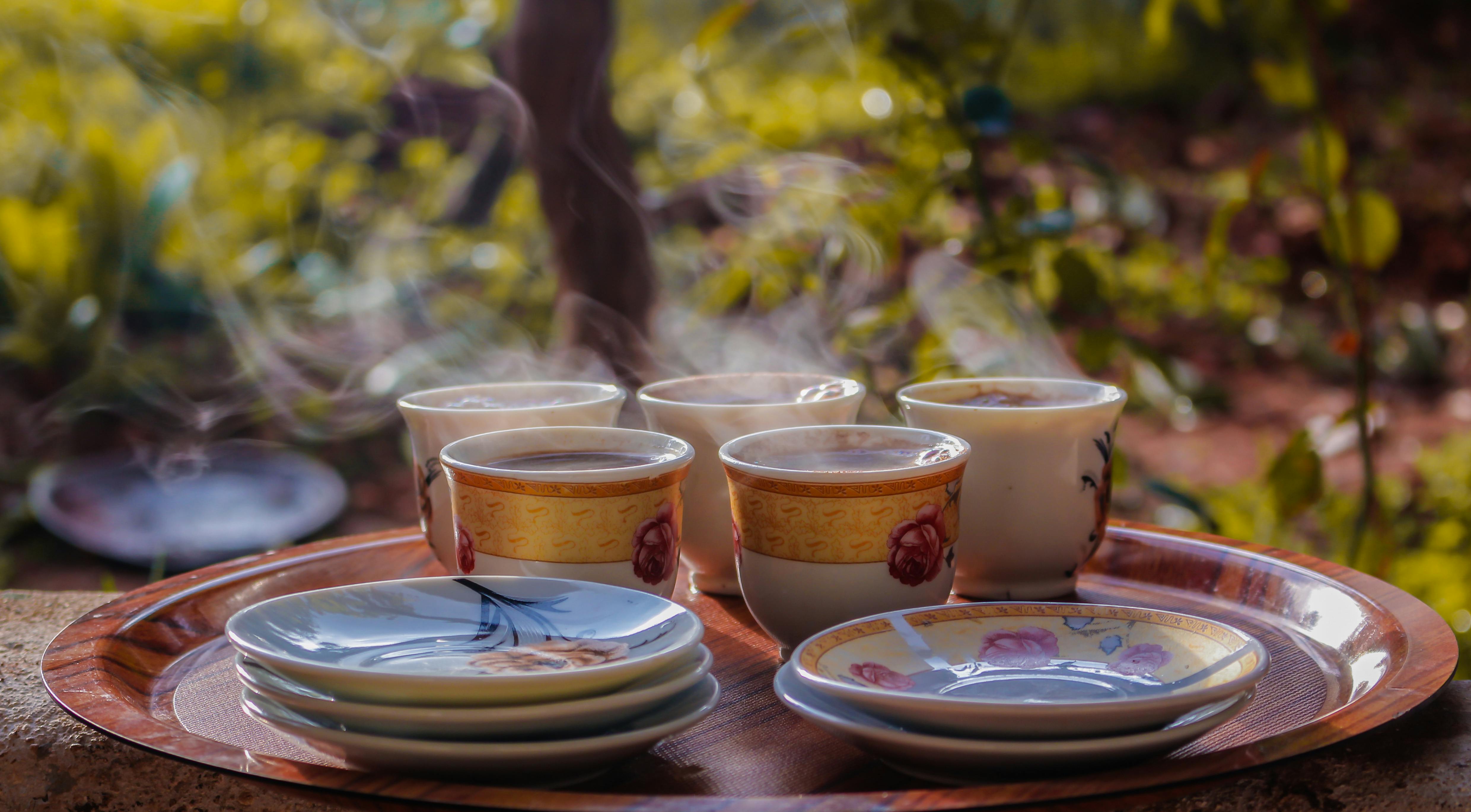 cups and saucers on round brown tray