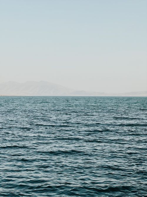 Free A tranquil ocean view with distant mountains under a clear sky. Stock Photo