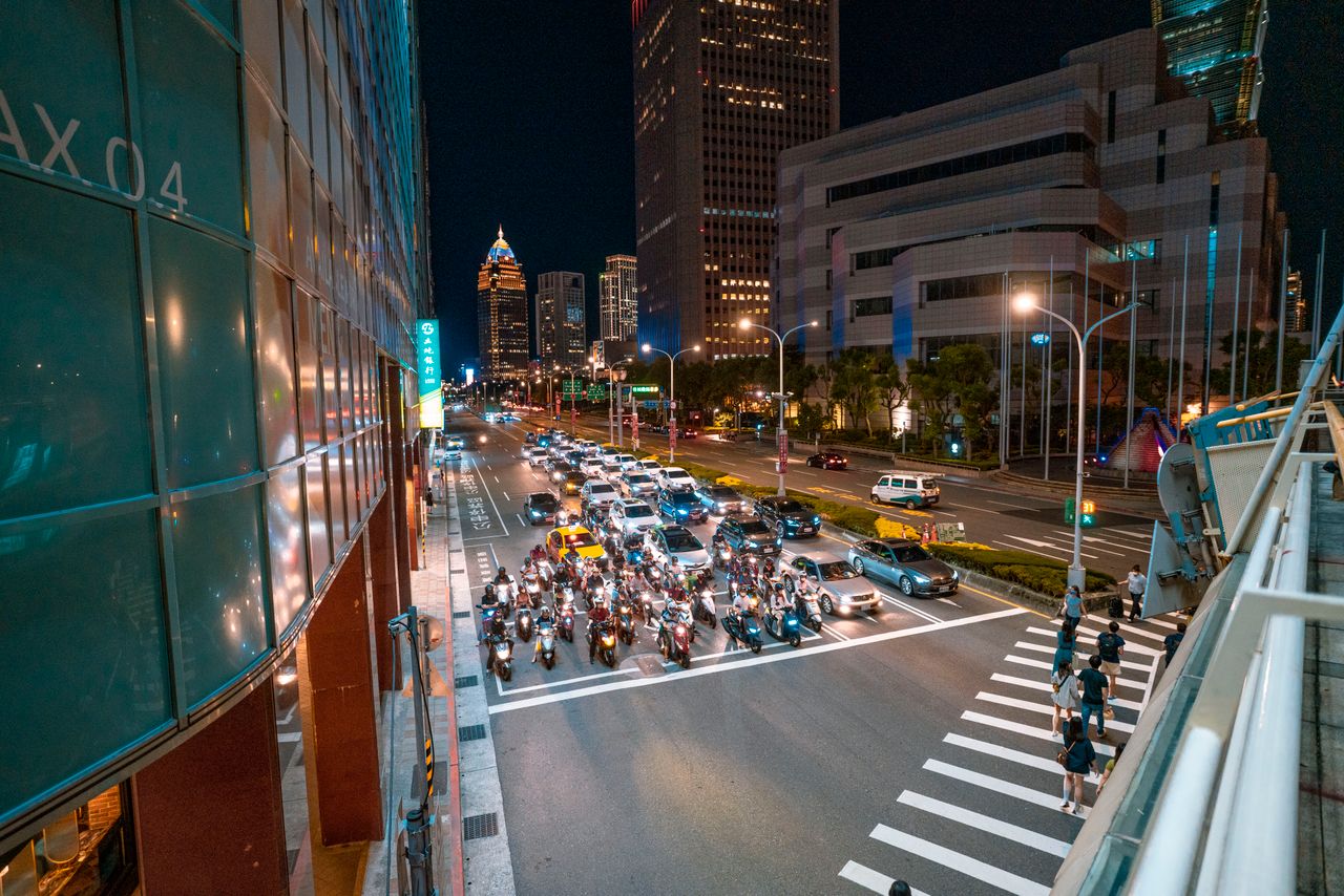 dynamic urban scene at night with bustling traffic and pedestrians cro