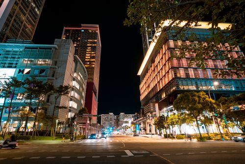 Free Dynamic city street at night featuring illuminated skyscrapers and vibrant traffic. Stock Photo