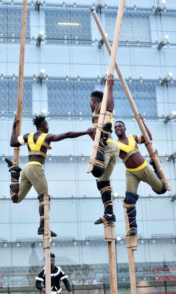 Group Of Men Walking On Stilts