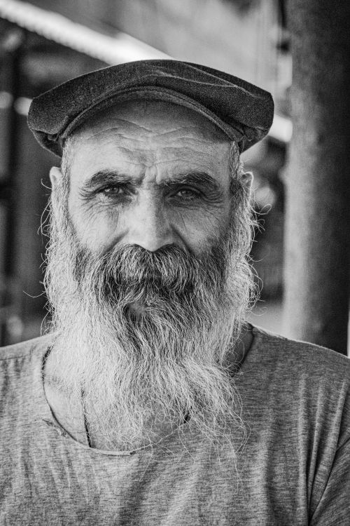 Free Grayscale portrait of an elderly bearded man in a cap exuding wisdom and character. Stock Photo