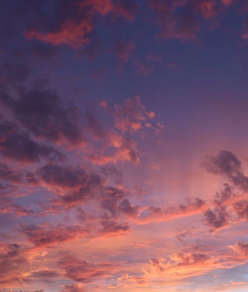Free A stunning sunset illuminates a dramatic sky with vivid colors and cloud formations. Stock Photo